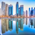 Stunning Dubai skyline at dusk featuring the Burj Khalifa and modern skyscrapers illuminated against a colorful evening sky with city lights reflecting on the water.