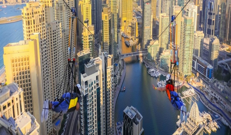 Thrilling view of XLine Dubai Marina, the world’s longest urban zipline, with riders soaring above skyscrapers and the vibrant Dubai Marina waterfront.
