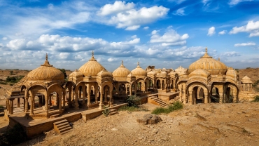 Bada Bagh cenotaphs in Jaisalmer, Rajasthan, featuring historic sandstone monuments in a desert setting during sunset.