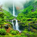 A vibrant, high-contrast image of Nanemachi Waterfall surrounded by bright green foliage, rocky cliffs, and misty hills in Maharashtra's Western Ghats.