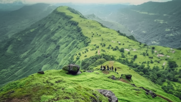 Trekking group on lush green Garbett Plateau during monsoon season near Matheran, Maharashtra.