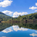 Scenic view of Chandoli forest reservoir reflecting blue sky and lush green hills